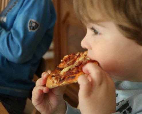 Kinder beim Pizza essen